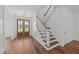 Elegant foyer with hardwood floors, white staircase, and stylish double doors leading to the outside at 125 Summerlin Dr, Clayton, NC 27527