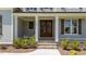 Inviting front porch with stone steps, manicured shrubs, and a stylish wooden double door entrance at 125 Summerlin Dr, Clayton, NC 27527
