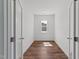 Hallway with beautiful dark-stained floors and natural light beaming through a large window at 125 Summerlin Dr, Clayton, NC 27527