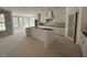 Bright kitchen with large windows, white cabinets, an island, and door to the pantry at 125 Summerlin Dr, Clayton, NC 27527