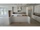 Spacious kitchen featuring white cabinets, a large island, and a door to the pantry at 125 Summerlin Dr, Clayton, NC 27527