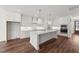 Spacious kitchen with a large island, modern white cabinets, and dark hardwood flooring at 125 Summerlin Dr, Clayton, NC 27527