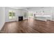 Open-concept living room flowing into a modern kitchen, featuring hardwood floors and fireplace at 125 Summerlin Dr, Clayton, NC 27527