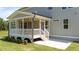 Covered porch features a ceiling fan, white railing, and steps leading down to the backyard at 125 Summerlin Dr, Clayton, NC 27527