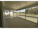 A lovely screened porch with wood flooring, looking out onto a green lawn and a treeline at 125 Summerlin Dr, Clayton, NC 27527