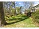 Spacious backyard with mature trees and lush green grass offers a serene outdoor space at 1302 Hermitage Rd, Sanford, NC 27330