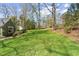 Expansive backyard with mature trees provides privacy and ample space for outdoor activities at 1302 Hermitage Rd, Sanford, NC 27330