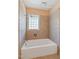 White bathtub with tile surround and a privacy window at 1302 Hermitage Rd, Sanford, NC 27330