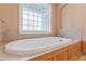 Large white bathtub with tile surround and privacy window at 1302 Hermitage Rd, Sanford, NC 27330