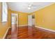 A bedroom with hardwood flooring and light yellow walls offers a glimpse into an adjacent bathroom at 1302 Hermitage Rd, Sanford, NC 27330