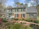 Charming two-story home with brick and siding, black shutters, and a beautifully landscaped front yard at 1302 Hermitage Rd, Sanford, NC 27330