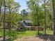 Home exterior with expansive lawn with mature landscaping and trees for a verdant backdrop at 1302 Hermitage Rd, Sanford, NC 27330