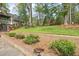 Retaining wall, landscaping and shrubs with a peek at the side of a lovely two-story home at 1302 Hermitage Rd, Sanford, NC 27330