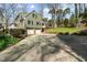 Spacious two-story home with a large driveway and attached two-car garage, framed by mature trees at 1302 Hermitage Rd, Sanford, NC 27330