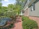 Charming home featuring a brick walkway, lush landscaping, and a welcoming front porch with white railings at 1302 Hermitage Rd, Sanford, NC 27330