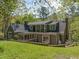 Exterior back of home highlighting yard and mature trees giving a sense of privacy at 1302 Hermitage Rd, Sanford, NC 27330