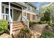 Inviting two-story home featuring a charming brick pathway leading to the covered front porch entrance at 1302 Hermitage Rd, Sanford, NC 27330