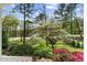 Picture-perfect view of the front yard with flowering trees from the covered front porch entrance at 1302 Hermitage Rd, Sanford, NC 27330
