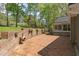 Spacious brick patio featuring a brick wall and lush trees, perfect for outdoor enjoyment and privacy at 1302 Hermitage Rd, Sanford, NC 27330