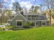 View of rear exterior showing siding, enclosed sun room and mature trees at 1302 Hermitage Rd, Sanford, NC 27330