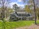 View of rear exterior showing siding, enclosed sun room and mature trees at 1302 Hermitage Rd, Sanford, NC 27330