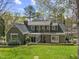 View of rear exterior showing siding, enclosed sun room and mature trees at 1302 Hermitage Rd, Sanford, NC 27330