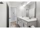Bright bathroom featuring a double sink vanity with white cabinets and modern fixtures and wood-look floors at 139 Pronghorn Deer Ct, Garner, NC 27529