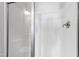 Bathroom stall featuring glass doors, toilet, built-in shower seat, and shower faucet at 139 Pronghorn Deer Ct, Garner, NC 27529