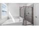 Bright bathroom featuring garden tub with tiled surround and glass shower at 139 Pronghorn Deer Ct, Garner, NC 27529