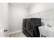 Laundry room featuring sleek, modern black appliances and a utility sink at 139 Pronghorn Deer Ct, Garner, NC 27529