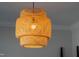 Close-up of a modern pendant light fixture with a unique woven design and warm lighting at 139 Pronghorn Deer Ct, Garner, NC 27529