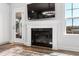 Living room with a fireplace, mounted TV, and view of the backyard through the glass door and windows at 139 Pronghorn Deer Ct, Garner, NC 27529