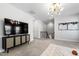 Spacious living room with television, modern chandelier, and staircase at 139 Pronghorn Deer Ct, Garner, NC 27529