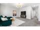 Living room with modern chandelier, green couch, flat screen television, and plush carpet at 139 Pronghorn Deer Ct, Garner, NC 27529
