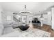 Open-concept living room with stylish chandelier, modern furniture, and seamless flow to the kitchen at 139 Pronghorn Deer Ct, Garner, NC 27529