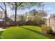 Backyard featuring a lush green lawn, tasteful landscaping, and privacy fencing at 1403 Wake Forest Rd, Raleigh, NC 27604