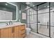 Modern bathroom featuring a glass-enclosed shower and soaking tub and a stylish wood vanity with stone countertop at 1403 Wake Forest Rd, Raleigh, NC 27604