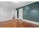 Bedroom featuring hardwood floors, designer wallpaper, and bright natural light at 1403 Wake Forest Rd, Raleigh, NC 27604