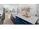 Bright kitchen with navy cabinets, white countertops, and an open view of the airy, window-filled living space at 1403 Wake Forest Rd, Raleigh, NC 27604