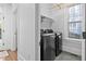 Modern laundry room featuring newer washer and dryer, and a built-in storage shelf at 1403 Wake Forest Rd, Raleigh, NC 27604