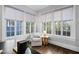 Bright living room featuring hardwood floors, a reading chair, and abundant natural light from large windows at 1403 Wake Forest Rd, Raleigh, NC 27604