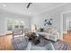 Living room with hardwood floors, comfortable seating, and view to the backyard at 1403 Wake Forest Rd, Raleigh, NC 27604