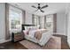 Spacious main bedroom with hardwood floors, a ceiling fan, and plenty of natural light from large windows at 1403 Wake Forest Rd, Raleigh, NC 27604