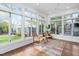 Sunroom with hardwood floors, large windows offering views of the fenced yard, and comfortable seating at 1403 Wake Forest Rd, Raleigh, NC 27604