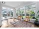 Bright sunroom with hardwood floors, large windows, and two chairs facing the backyard at 1403 Wake Forest Rd, Raleigh, NC 27604