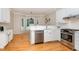 Bright kitchen features stainless appliances, white cabinetry, light countertops and hardwood flooring at 15101 Aiken Rd, Wake Forest, NC 27587