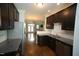 A modern kitchen featuring a stainless steel refrigerator and sink, open to the living room at 1523 Yarborough Park Drive, Raleigh, NC 27604