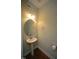 Stylish powder room featuring pedestal sink, round mirror and modern fixtures at 1523 Yarborough Park Drive, Raleigh, NC 27604