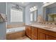 Well-lit bathroom with a double vanity, soaking tub, and stylish tile backsplash at 1525 Marshall Farm St, Wake Forest, NC 27587