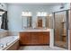 Bathroom with double vanity, soaking tub, and glass-enclosed shower stall at 1525 Marshall Farm St, Wake Forest, NC 27587
